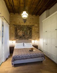 罗德镇Tafros Villa的一间卧室设有一张带砖墙的大床
