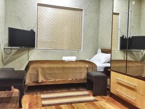 KhorogZarya Hotel的一间卧室配有一张床和一台平面电视