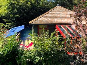艾瓦耶Vintage Chalet in Sougn Remouchamps near Forest的一个带遮阳伞和椅子的小房子