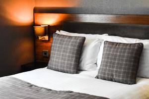 马瑟韦尔丹泽公园酒店 的一张带白色床单和枕头的床