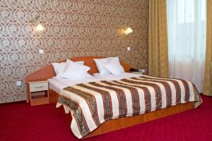 阿拉德Hotel Xemar的酒店客房,配有带条纹毯子的床
