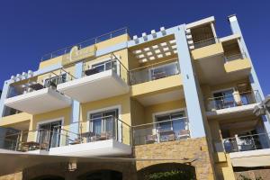 阿尔库季岛阿尔米拉酒店 的带阳台的黄色建筑和蓝色的天空
