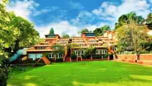 科代卡纳尔Kodai Resort Hotel, Kodaikanal的前面有绿色草坪的大建筑