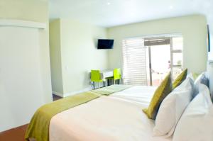 布鲁堡史特兰Small Bay Guest House的卧室配有一张带黄色枕头的大型白色床。