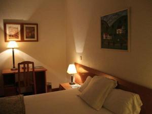 托雷维耶哈Hostal Gran Via Levante的配有两张枕头的床的酒店客房