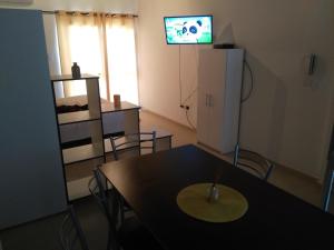 圣胡安Departamento Andino del Sol的一间设有桌子和墙上电视的用餐室
