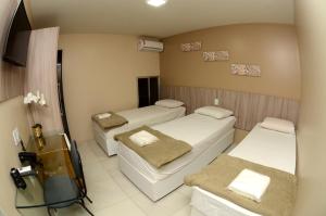 卡鲁阿鲁Hotel Itaparica的一间医院,配有三张床和电视