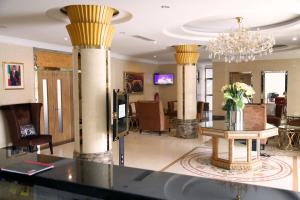 布拉柴维尔Hotel Amaritsah的大厅,设有圆柱、桌子和吊灯