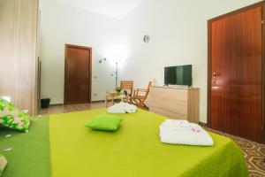 阿沃拉B&B U PRUFISSURI的一间卧室配有绿床和毛巾