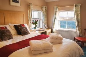 朗德斯通Island View Roundstoneselfcatering的一间卧室配有带毛巾的床