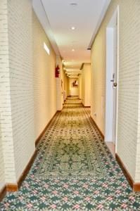 布宜诺斯艾利斯Hotel 6 de Octubre的楼面上铺着地毯的酒店走廊