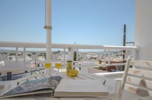 纳克索乔拉Naxos Dream Oniro Studios - Adults Only的阳台上的桌子上摆放着书籍和酒杯
