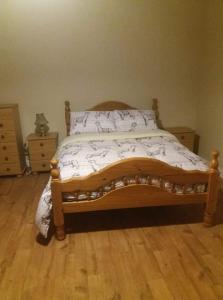 凯尔斯Castletownmoor Clinic & Permaculture Farm的一间卧室配有一张木床,铺有木地板