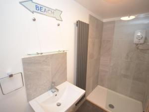 谢林汉姆Beach hut seaside cottage的浴室配有白色水槽和淋浴。