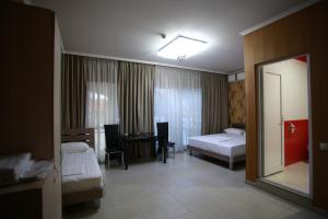 第比利斯第比利斯奥克里巴酒店的酒店客房,设有两张床和镜子