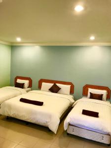 瓜拉江沙Hotel Seri Kangsar KK Hotel的带绿色墙壁的客房内的三张床