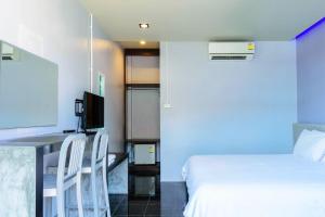 奥南海滩洛马广场酒店的一间卧室配有一张床和一张书桌及电视