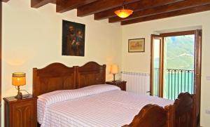 特雷莫西内Casa De Pol Exclusive Lake View by Gardadomusmea的一间卧室设有一张木床和一个窗户。