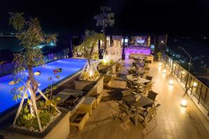 日惹Satoria Hotel Yogyakarta - CHSE Certified的一间设有桌子的室外餐厅,晚上则设有游泳池