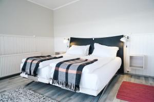 海德利桑德Kleifar: Ocean View Apartment的一间卧室配有一张白色的床和黑色床头板
