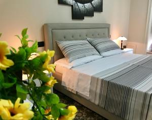 皮亚扎-阿尔梅里纳B&B Villa Roma的卧室的一张床位,前方有黄色的鲜花