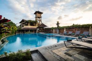 塞米亚克巴厘阿玉酒店&别墅的一座大型游泳池,后面有一座塔楼