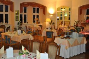 BehringenSchlosshotel am Hainich的餐厅配有桌椅和白色桌布