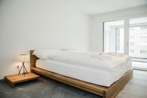 因特拉肯Apartment JungfrauCenter Schynige Platte - GriwaRent AG的白色的卧室设有一张大床和一个窗户