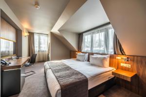 索非亚All Seasons Residence Hotel - Free parking的一间卧室配有一张大床、书桌和窗户