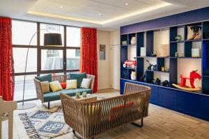 普罗旺斯艾克斯普罗旺斯地区艾克斯中心阿德吉奥公寓式酒店的客厅拥有蓝色的墙壁和沙发