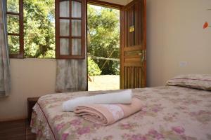 伊瓜苏Iguassu Eco Hostel - IguassuEcoHostel - Eco Suítes的一间卧室配有一张床,床上有毛巾