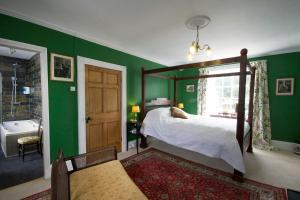多尔盖罗普拉斯格温住宿加早餐酒店及度假小屋的一间卧室设有绿色的墙壁、一张床和一个浴缸