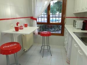 托莱多El Balcón del Tajo的厨房配有两个红色凳子和一个柜台