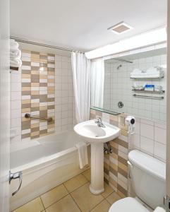 蒙特利尔公寓酒店的一间带水槽、浴缸和卫生间的浴室