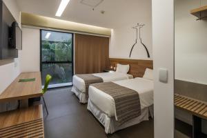 里约热内卢林科斯加雷奥酒店的酒店客房设有两张床和窗户。