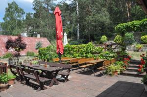 斯塔勒斯普拉维Penzion Zuzana的庭院设有桌子、长凳和红色雨伞。