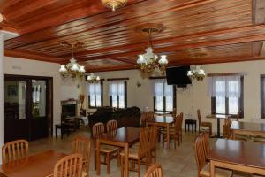 Vradéton巴尔肯尼扎戈里亚旅馆 的用餐室设有木制天花板和桌椅