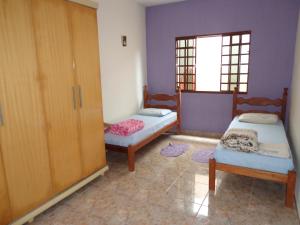 圣罗克迪米纳斯Casa Serra da Canastra - Chicó的客房设有两张床、一个橱柜和一个窗户。