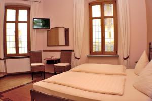 贝尔恩卡斯特尔-库斯默塞布鲁根酒店餐厅的一间卧室设有两张床、一张桌子和两个窗户。