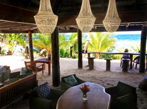 Qamea迈琪海滩生态度假酒店的海滩上带桌椅的餐厅