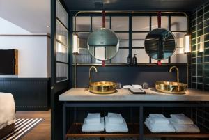 香港芬名酒店的浴室设有2个盥洗盆和镜子,位于柜台上