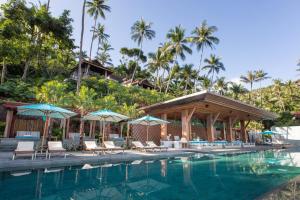 湄南海滩Four Seasons Resort Koh Samui的度假村的游泳池,配有椅子和遮阳伞