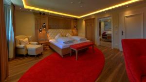 安德希斯Boutique Hotel POST ANDECHS的一间卧室配有一张大床和红色地毯。