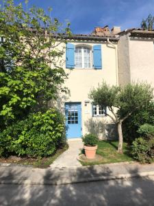 格里莫Maison d'Azur的一座有蓝色门和一棵树的房子