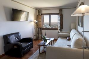 托莱多帕拉多托莱多酒店的客厅配有沙发和两把椅子