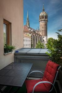 路德斯塔德·威特比Ferienwohnungen am Schloss的红色椅子坐在阳台与大楼