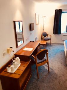 利明顿温泉斯托莱公园旅馆的客房设有书桌、床和镜子