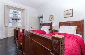 DonoureGalley Head Lightkeeper's Houses的一间卧室设有两张带红色床单的床和窗户。