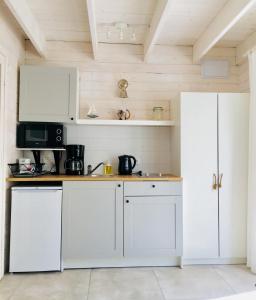 波别罗沃8 Sosen Pobierowo的厨房配有白色橱柜和微波炉