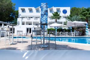 帕格拉La Concha Soul Boutique Hotel的酒店前方设有1个带桌子和遮阳伞的游泳池。